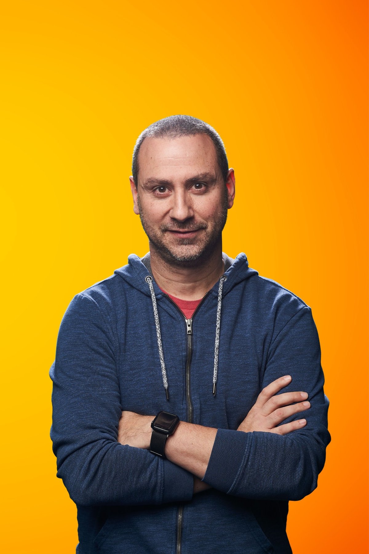 Matt Radicelli in a blue hoodie against an orange backdrop